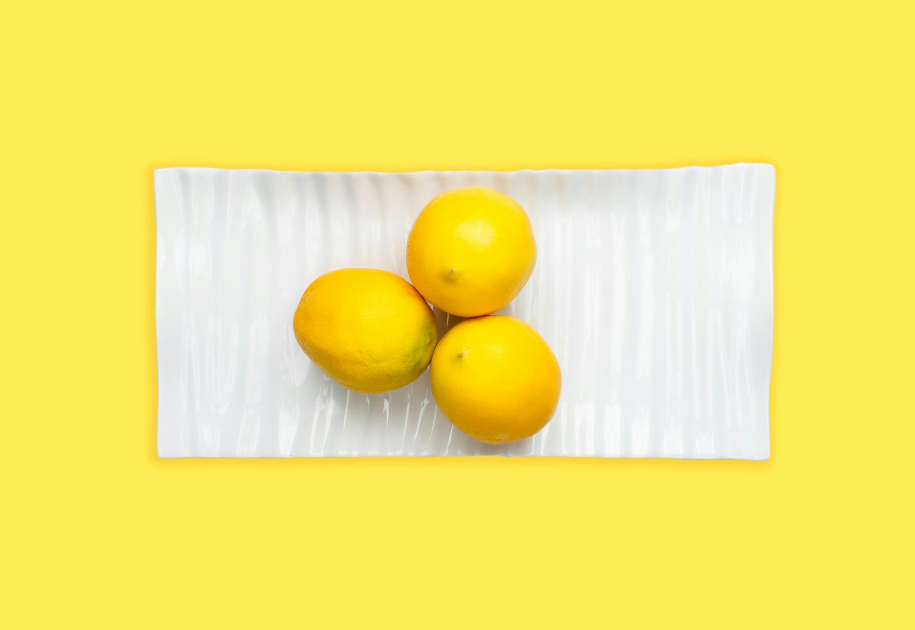 Studio setup showcasing colorful lemon clitoral vibrators on a bright yellow background