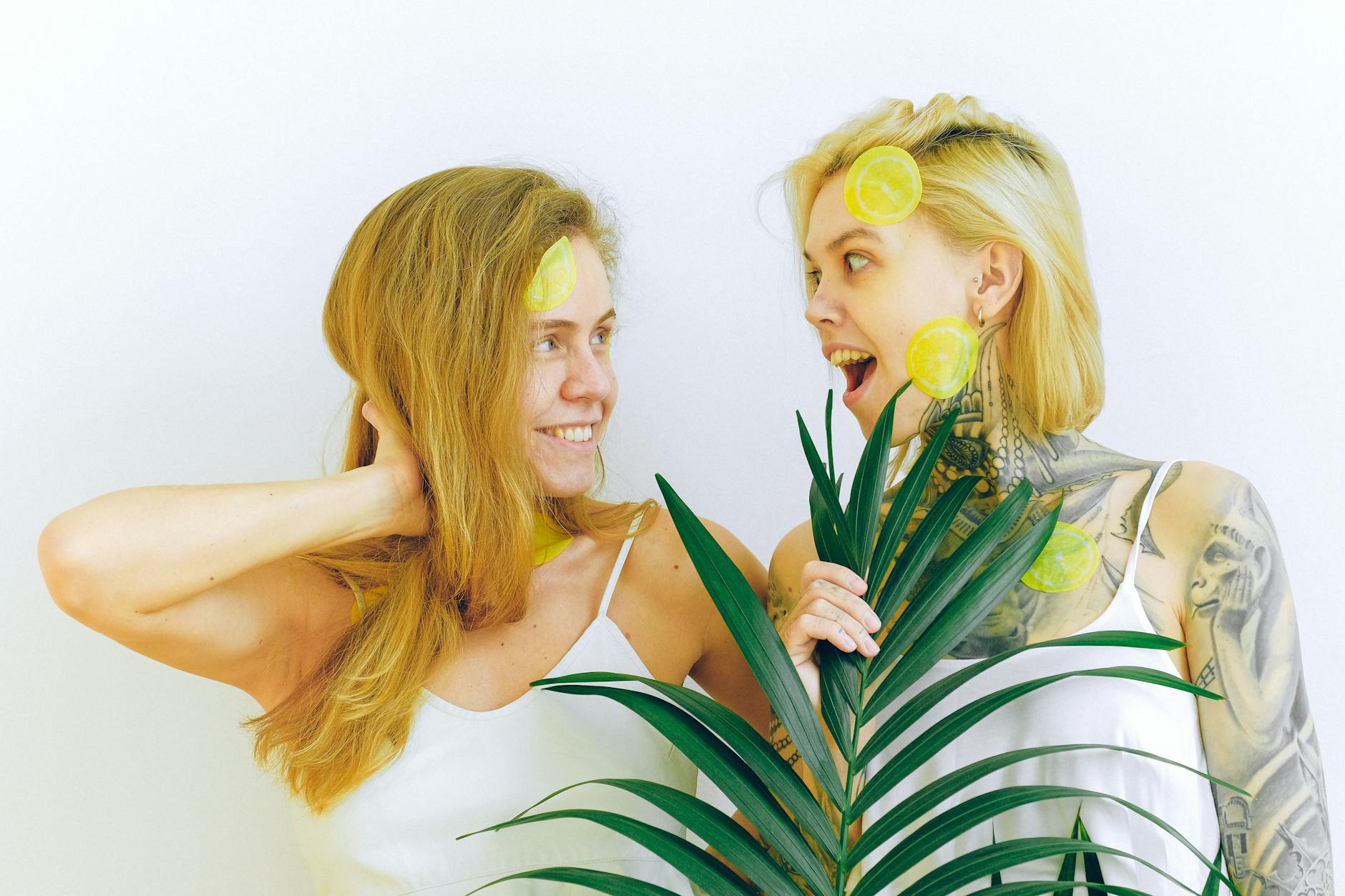 Two women smiling together with fresh lemons, celebrating joy and vitality