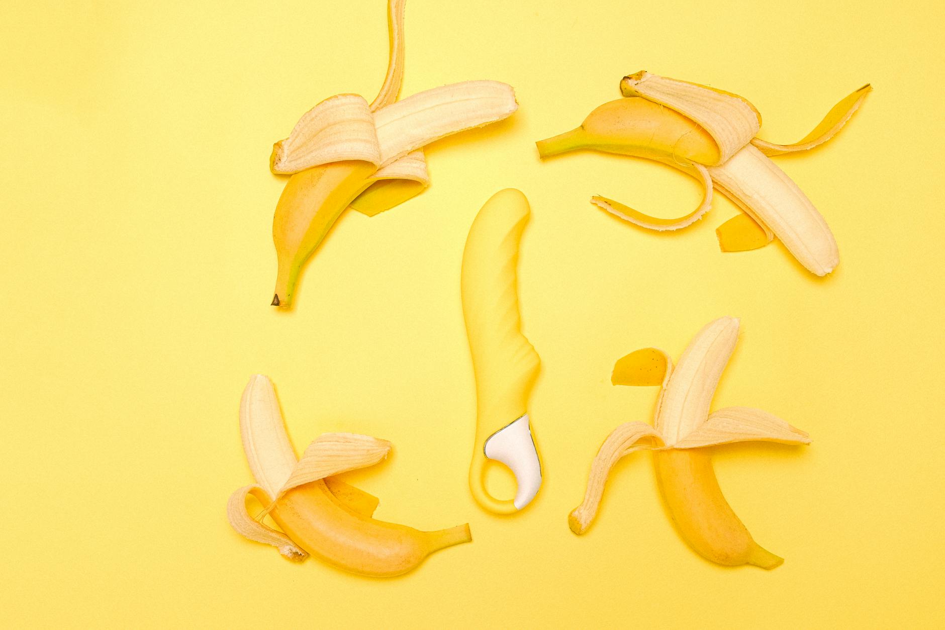 Yellow lemon vibrator surrounded by fresh lemons on a bright background