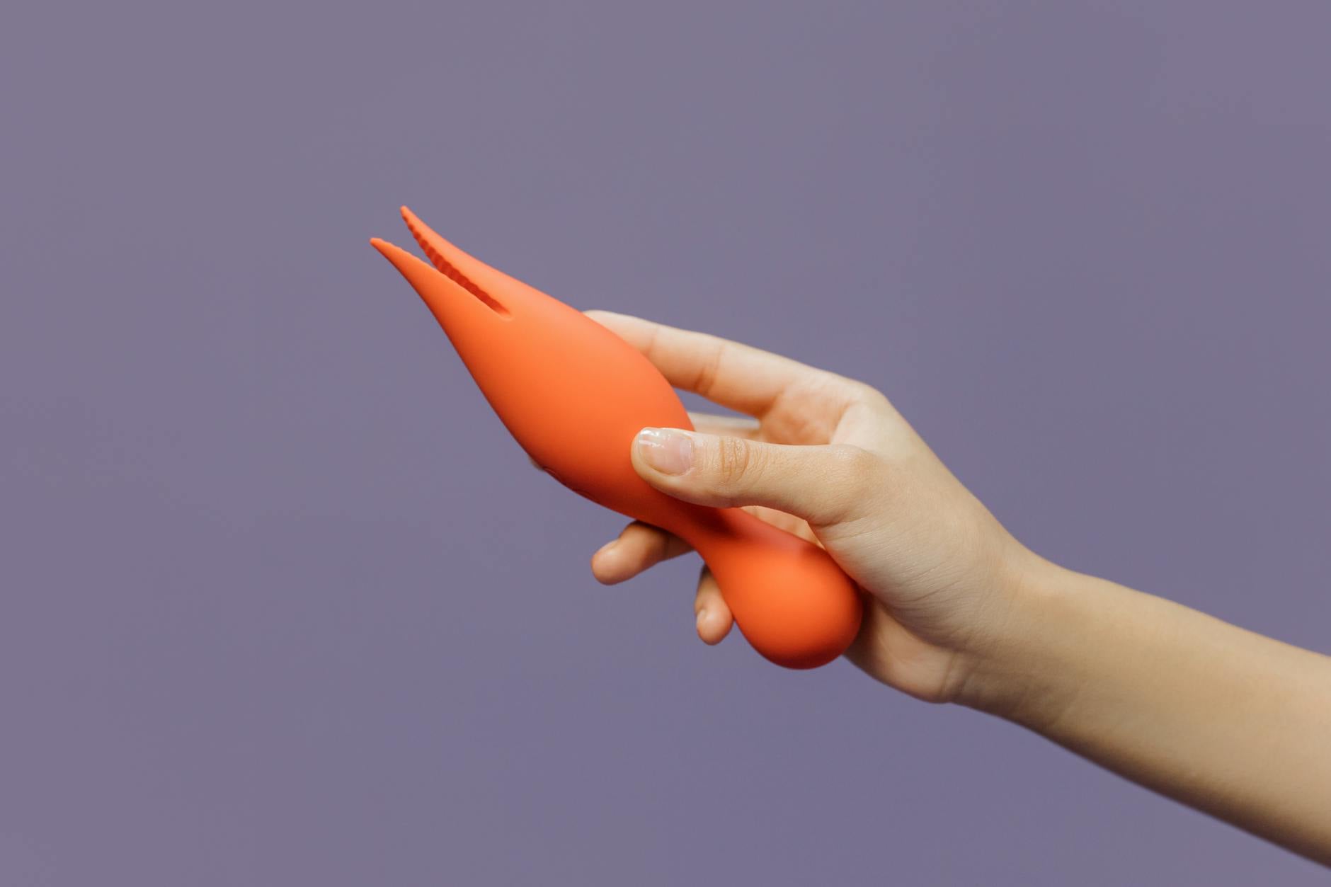Close-up of a hand holding a lemon-colored vibrator against a minimalist backdrop, symbolizing comfort and accessible pleasure.