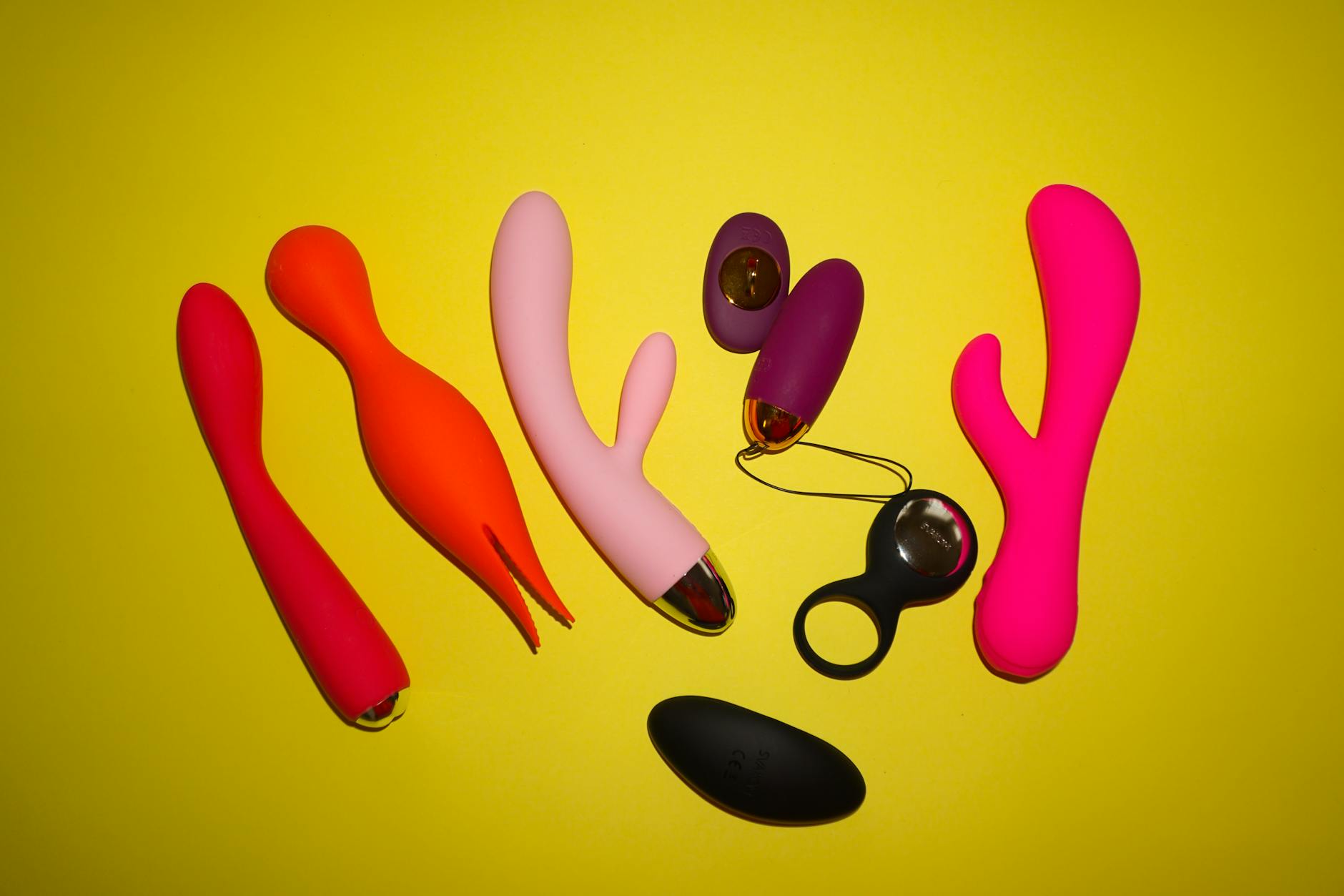 A blue silicone lemon vibrator held in hand against a solid purple background